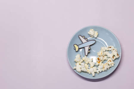 A toy plane flies on a blue plate above popcorn clouds.の写真素材
