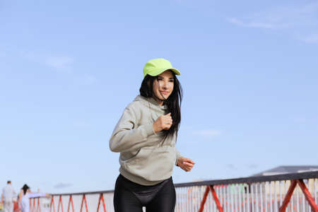 A woman in sweatshirts runs in the morning workout.