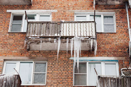 Russia. Terrible huge icicles formed on the balcony of a multi-storey building due to a poor roof storm system.の写真素材
