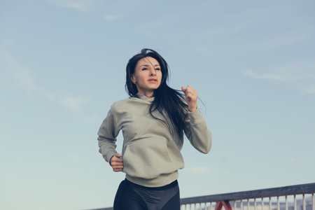 A woman in sweatshirts runs in the morning workout.の写真素材