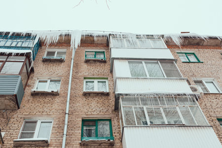 Russia. Terrible huge icicles formed on the balcony of a multi-storey building due to a poor roof storm system.の写真素材