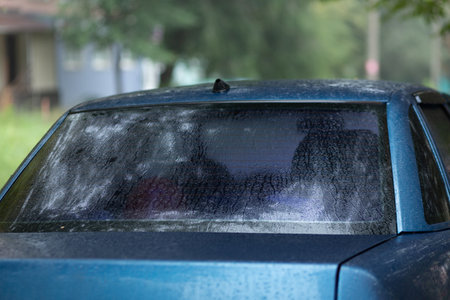 Tinted rear window of a car with raindrops.の写真素材