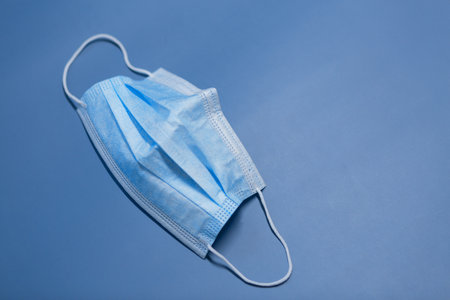 Medical three-layer mask on a blue background.の写真素材