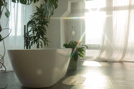 White bathroom with flowers and large windows.の写真素材