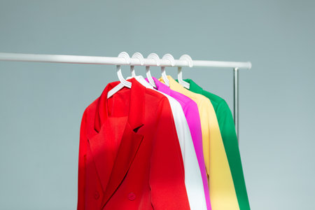 Multi-colored bright jackets on a hanger on a white backgroundの写真素材