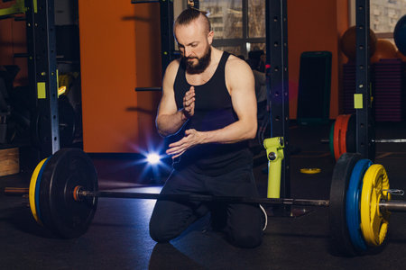 A man of athletic build is preparing to perform an exercise with a barbellの写真素材