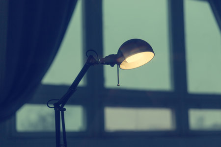 Table lamp on a wooden table on a blue background.の写真素材