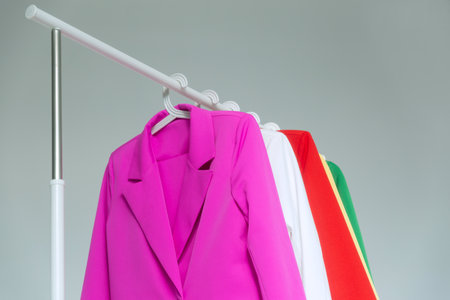 Multi-colored bright jackets on a hanger on a white background.の写真素材