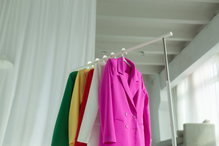 Multi-colored bright jackets on a hanger on a white background.の写真素材