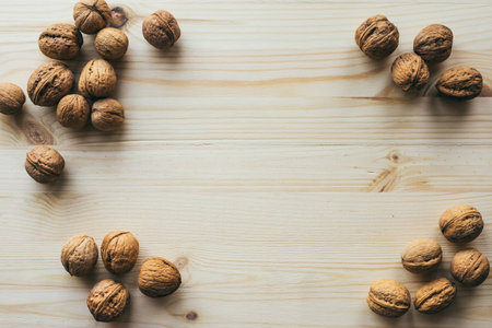frame of walnuts on a wooden table. place for your own text