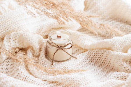 Soy wax candle in amber glass with dried flowers. Handmade candle with copy space. Beige toned photo.の写真素材