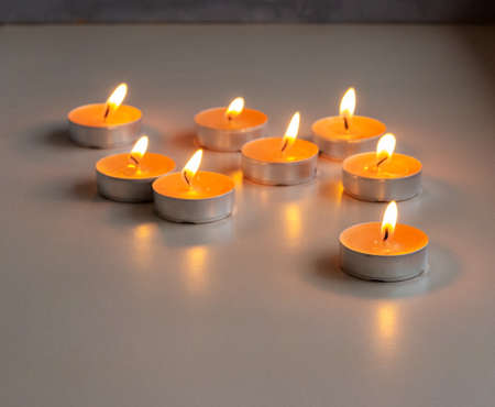 Set of little orange burning candles on the table
