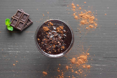 Hot chocolate in a glass on the wooden background. Tasty, delicious dessert.の写真素材