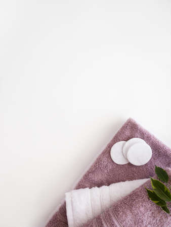 Pink and white towels with cotton pads on the white background. bathroom accessories. copyspace.の写真素材