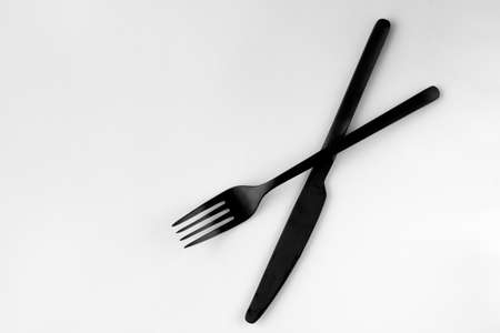 Black fork and knife isolated on white background. top view.の写真素材