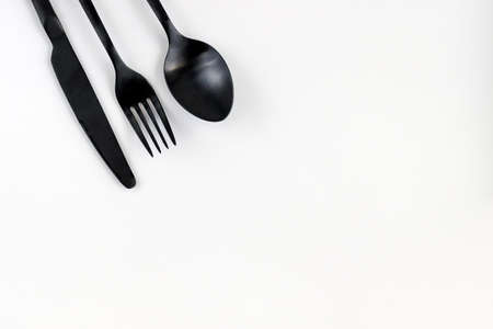 Black fork, spoon, knife isolated on white. Flat lay, top view.の写真素材