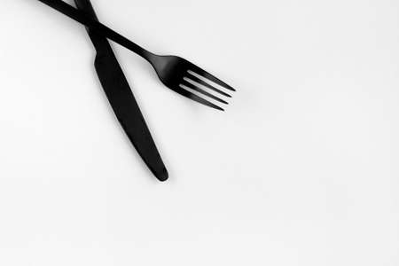 Black fork and knife isolated on white background. top view.の写真素材