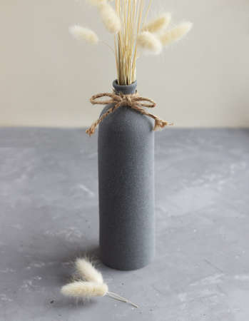 Elegant vase with dried lagurus bouquet on the concrete table. home decoration composition.の写真素材