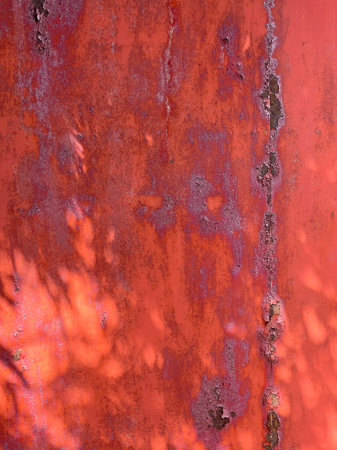 Peeled red paint on metal iron background with shadows