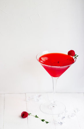 Red alcohol cocktail with raspberries and thyme on the white wood table.の写真素材