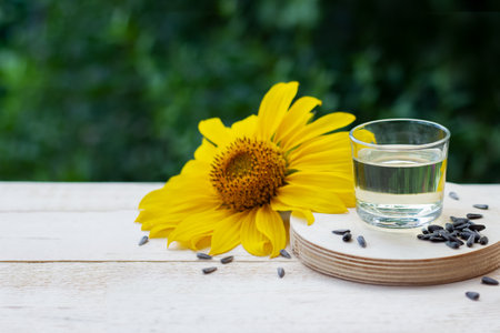 Close-up of sunflower oil in glass with seeds and sunflowerの写真素材