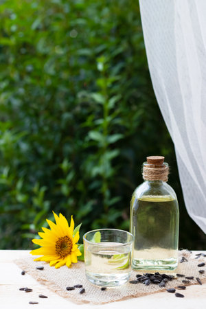 Close-up of sunflower oil in a bottle glass with seeds and sunflowerの写真素材