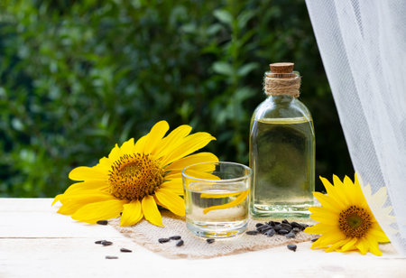 Close-up of sunflower oil in a bottle glass with seeds and sunflowerの写真素材