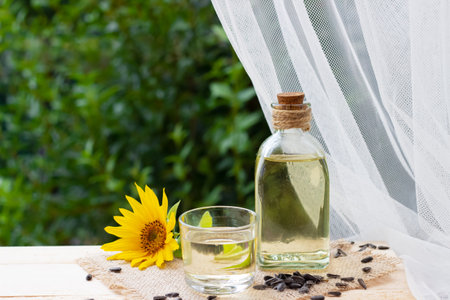 Close-up of sunflower oil in a bottle glass with seeds and sunflowerの写真素材