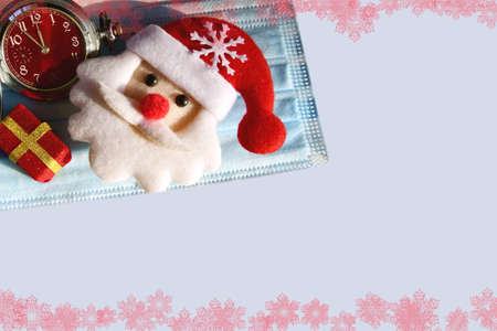 Christmas background with Christmas gifts on a medical mask on a blue background with a place for an...