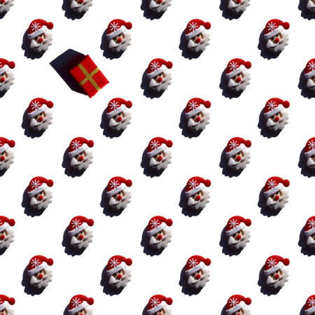 large pattern of Santa Clauses and one gift, a symbol of the holidays of Christmas and New Year. Flat layの写真素材