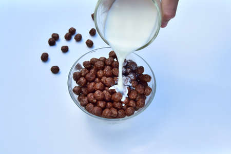 Delicious fresh milk and chocolate flakes for children's Breakfast. the concept of healthy eating, a drop of milk on chocolate cerealの写真素材