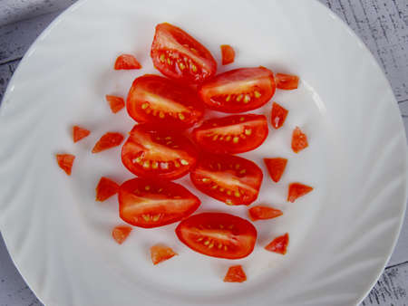 cherry tomatoes cut into pieces on white terelle top view. close up. vegetarian healthy food.の写真素材