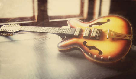 Electric guitar on a table in front of a window macro abstractionの写真素材