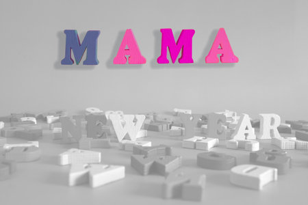 word mama on a black and white background consists of colorful wooden letters in the abc alphabet block, which are the place for the ad text. English learning conceptの写真素材
