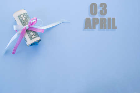 calendar date on blue background with rolled up dollar bills pinned by blue and pink ribbon with...