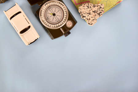 Travel reliability and confidence. Magnetic compass on a blue background with a map and a car. Traveling in your own car in a period of new normal.の写真素材