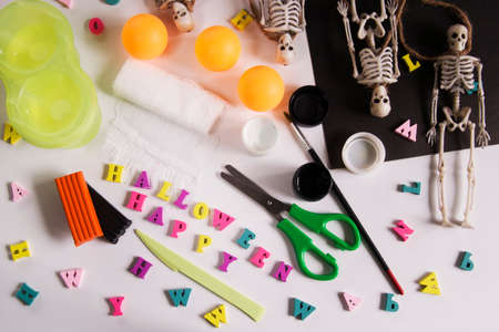Paper, bandage, plasticine with paints on a wooden table. Halloween greeting card spider and cobweb, ghost skeletons. Crafts for childrenの写真素材