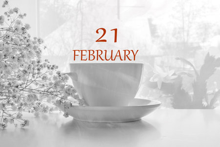 calendar date on light background with porcelain white tea pair and white gypsophila with copy space. February 21 is the twenty first day of the month.の写真素材