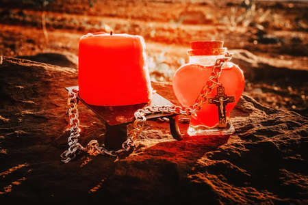 burning candle, a symbol of the moon, an amulet lying on the moss on a dark natural background. pagan wiccan, slavic traditions. Witchcraft, esoteric spiritual ritual for mabon, halloween, samhain. autumn equinox festival.の写真素材