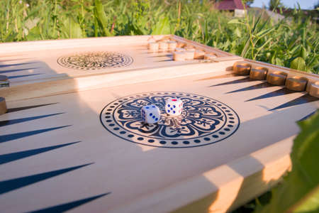 throwing dice in backgammon board game close up. Foreground soft focus.
