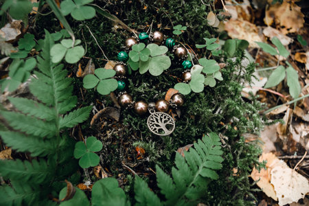 amulet lies on green moss with clover on a dark natural background. pagan wiccan, slavic traditions....