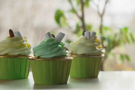 Chocolate cupcake with creamy pistachio and lemon glaze on a light background. Template for displaying product presentationの写真素材