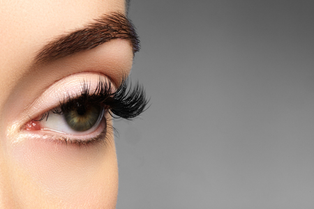 Beautiful macro shot of female eye with extreme long eyelashes and black liner makeup. Perfect shape make-up and long lashes. Cosmetics and make-up. Closeup macro shot of fashion eyes visageの写真素材
