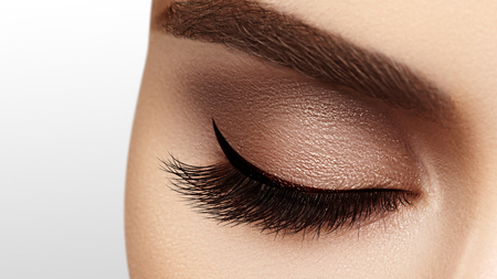 Beautiful macro shot of female eye with extreme long eyelashes and black liner makeup. Perfect shape make-up and long lashes. Cosmetics and make-up. Closeup macro shot of fashion eyes visageの写真素材
