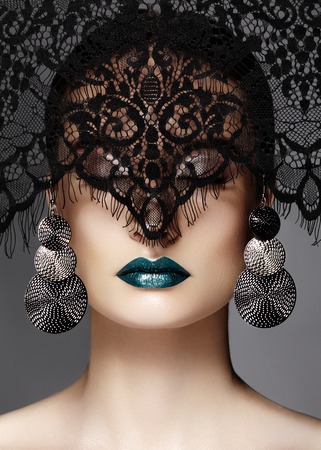 Luxury Woman with Celebrate Fashion Makeup, silver Earrings, black dramatic Lace veil. Halloween sexy witch look or luxe Christmas style. Green metallic Lips Make-upの写真素材