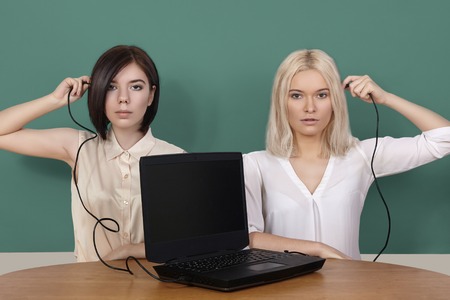 Girls connecting black laptop. Distance Learning, home schooling. Cybernetic age in Internet. Opportunity for work and education.の写真素材