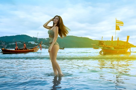 Beautiful retro styled model wearing print swimsuit. Sexy model on the beach.の写真素材