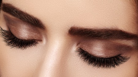 Beautiful macro shot of female eye with extreme long eyelashes and black liner makeup. Perfect shape make-up and long lashes. Cosmetics and make-up. Closeup macro shot of fashion eyes visageの写真素材