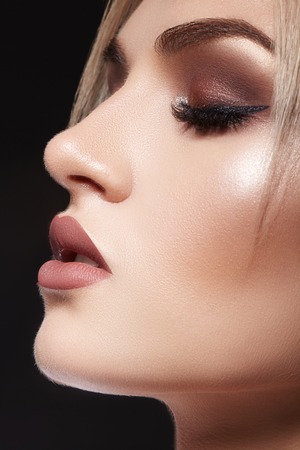 Closeup portrait with of beautiful woman face. Fashion makeup, clean shiny skin. Makeup and cosmetic. Beauty style on model face. Blond hair styleの写真素材