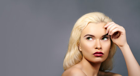 Horizontal portrait of Beautiful Woman with Pout sensual red Lips Make-Up, Blond Hair Fink about New Idea and Looking at Something. Sexy Retro Pin-Up Styleの写真素材